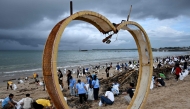 Participants and volunteers remove plastic waste and other garbage washed ashore at a beach in Kedonganan Badung regency, Indonesia's Bali island on January 4, 2025. (Photo by Sonny Tumbelaka / AFP)