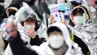 Demonstrators wear thermal blankets during a rally against impeached South Korea President Yoon Suk Yeol near his residence in Seoul on January 5, 2025. Photo by Philip FONG / AFP.