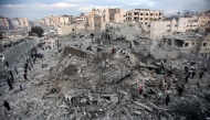 People and first responders inspect the rubble of a collapsed residential building that was hit by Israeli bombardment in the Saraya area in al-Rimal,  central Gaza on January 4, 2025. (Photo by Omar Al-Qattaa / AFP)
