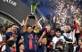 Paris Saint-Germain players celebrate with the trophy after winning the French Champions' Trophy (Trophee des Champions) final football match between Paris Saint-Germain (PSG) and AS Monaco (ASM) at the Stadium 974 in Doha on January 5, 2025. (Photo by Mahmud HAMS / AFP)