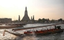 Tourists ride a longtail boat past Wat Arun temple along the Chao Praya river in Bangkok on December 19, 2024. Photo by Lillian SUWANRUMPHA / AFP