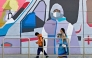 Pedestrians walk past a wall mural promoting awareness on using face masks, in Bengaluru on January 6, 2025. Photo by Idrees MOHAMMED / AFP