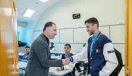 A teacher welcomes a student in the classroom. 