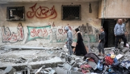 Rubble and salvaged clothes are piled in a street outside an apartment building hit by Israeli bombardment in the Bureij camp for Palestinian refugees in the central Gaza Strip on January 7, 2025. (Photo by Eyad Baba / AFP)