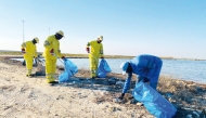 Municipality staff clean a beach. 