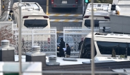 Security personnel check vehicles at the entrance gate of the presidential residence of impeached South Korea President Yoon Suk Yeol, as seen from a hill in Seoul on January 8, 2025. (Photo by Jung Yeon-je / AFP)