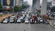 A man rides a motorbike in front of vehicles waiting at a red light at an intersection in Hanoi on January 8, 2025. (Photo by Nhac NGUYEN / AFP)
