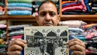 Resident Rajiv Kumar shows a photograph at his shop near Carterpuri village in Gurgaon on January 7, 2025, picturing late former US president Jimmy Carter and his wife Eleanor Rosalynn Carter during their visit to the eponymous village in 1978. (Photo by Money Sharma / AFP)