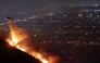 A firefighting helicopter drops water as the Sunset Fire burns in the Hollywood Hills with evacuations ordered on January 8, 2025 in Los Angeles, California. Mario Tama/Getty Images/AFP