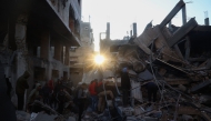 People search the rubble of a building destroyed in an Israeli strike on the Bureij camp for Palestinian refugees in the central Gaza Strip on January 8, 2025 as the war between Israel and the Palestinian Hamas movement continues. (Photo by Eyad Baba / AFP)