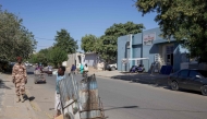 A Chadian soldier (L) looks on as a man with a cart gestures on a street in the Djambal Bahr district of N'Djamena on January 9, 2025. (Photo by Joris Bolomey / AFP)