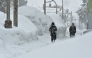 Pedestrians walk past high drifts of snow along a street in the northern Japanese city of Aomori on January 9, 2025. (Photo by JIJI Press / AFP) / Japan OUT