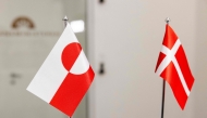 The Greenlandic (L) and Danish flags are pictured at the Ministry of Finance in Copenhagen on January 8, 2025. (Photo by Nikolai Linares / Ritzau Scanpix / AFP) 