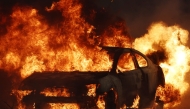 A vehicle burns during the Eaton Fire on January 8, 2025 in Altadena, California. Over 1,000 structures have burned, with two people dead, in wildfires fueled by intense Santa Ana Winds across L.A. County. Mario Tama/Getty Images/AFP (Photo by MARIO TAMA / GETTY IMAGES NORTH AMERICA / Getty Images via AFP)