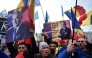 People wave Romanian flags and hold portraits of far-right presidential candidate Calin Georgescu during a protest in front of Romania's Constitutional Court in Budapest on January 10, 2024. (Photo by Daniel MIHAILESCU / AFP)