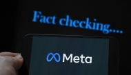 (Files) This photo illustration created on January 8, 2025, in Brussels, shows the media giant Meta's logo displayed on a smartphone and screen displaying the words 