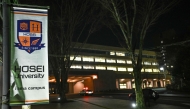 A banner (L) for Hosei University is pictured near the entrance to the university's Tama campus after a woman brandished a hammer inside a classroom, in Machida in the western suburbs of Tokyo on January 10, 2025. Photo by Philip FONG / AFP