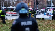 Demonstrators protesting against Germany's far-right Alternative for Germany (AfD) party hold banners reading 