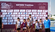 Young athletes celebrate on the podium at the conclusion of the Katara Triathlon Championship.