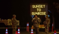 National Guard officers close a street enforcing a curfew in evacuation order zones and evacuation warning zones from 6pm to 6am as wildfires cause damage and loss through LA region on January 11, 2025 in Santa Monica, California. (Photo by Apu Gomes/Getty Images/AFP)