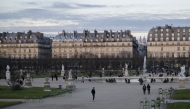 Pedestrians walk past the Grand Bassin Rond of the Tuileries Garden with the Sacre Coeur Basilica in the background in central Paris, on January 10, 2025. (Photo by Martin LELIEVRE / AFP)