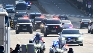 A motorcade carrying impeached South Korea President Yoon Suk Yeol arrives at the complex building housing the Corruption Investigation Office for High-ranking Officials (CIO) in Gwacheon on January 15, 2025, after Yoon was arrested over his failed martial law bid. (Photo by Korea Pool / AFP) 