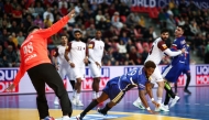 France’s Benoit Kounkoud shoots to score a goal against Qatar.