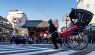 A rickshaw carrying a tourist drives down the street in front of Sensoji Temple in Asakusa, Tokyo on January 14, 2025. Photo by Kazuhiro NOGI / AFP