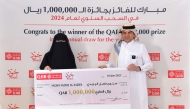 QIIB CEO, Dr. Abdulbasit Ahmed Al Shaibei presenting the cheque to the winner of 2024 QR1m prize in ‘Joud’ savings account draw.