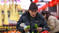 A customer picks vegetables at a supermarket in Nanjing, east China's Jiangsu province on January 17, 2025. Photo by AFP