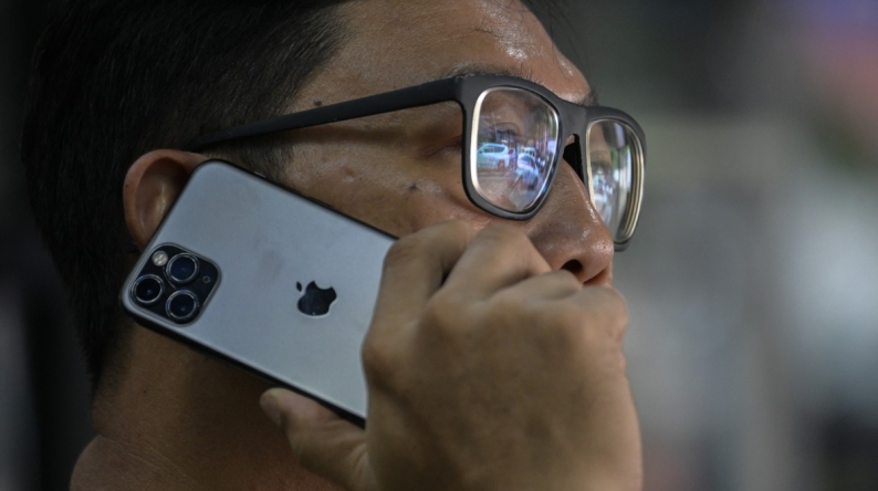 A man uses an Apple iPhone in Jakarta on January 8, 2025. (Photo by BAY ISMOYO / AFP)
