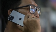 A man uses an Apple iPhone in Jakarta on January 8, 2025. (Photo by BAY ISMOYO / AFP)
