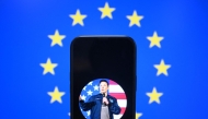 This illustration photograph shows Elon Musk's X (formerly Twitter) account displayed on a smartphone in front a European Union flag in Brussels on January 7, 2025. Photo by Nicolas TUCAT / AFP