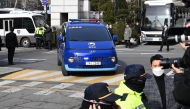 A blue van believed to be transporting impeached South Korea President Yoon Suk Yeol arrives at the Seoul Western District Court in Seoul on January 18, 2025, for a hearing which will decide whether to extend Yoon's detention as investigators probe his failed martial law bid. (Photo by JUNG YEON-JE / POOL / AFP)
