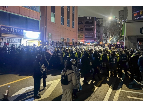 Police stand guard on a street near the Seoul Western District Court in Seoul, early on January 19, 2025, after hundreds of pro-Yoon protesters smashed windows and broke down doors to enter the court following the extension of the detention of impeached South Korea President Yoon Suk Yeol. Photo by Jin-kyu Kang / AFP