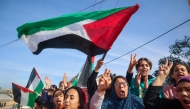 Displaced Palestinians wave national flags as they return to Rafah, in the southern Gaza Strip, on January 19, 2025. (Photo by Eyad Baba / AFP)