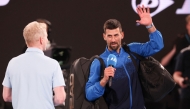 Serbia's Novak Djokovic (R) speaks into the microphone on court after winning his men's singles match against Czech Republic's Jiri Lehecka in Melbourne on January 19, 2025. (Photo by David Gray / AFP)