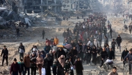 Scores of displaced Palestinians walk along a road in the Saftawi area of Jabalia, as they leave areas near Gaza City where they had taken refuge, toward the further northern part of the Gaza Strip, shortly after a ceasefire deal was expected to be implemented. (Photo by Omar Al-Qattaa / AFP)