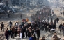 Scores of displaced Palestinians walk along a road in the Saftawi area of Jabalia, as they leave areas near Gaza City where they had taken refuge, toward the further northern part of the Gaza Strip, shortly after a ceasefire deal was expected to be implemented. (Photo by Omar Al-Qattaa / AFP)