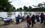 Displaced people from recent clashes between armed groups wait to cross the Tarra River, which divides Colombia and Venezuela, in Tibu, Norte de Santander department, Colombia, on January 19, 2025. (Photo by Schneyder Mendoza / AFP)