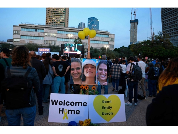 Supporters and relatives of Israeli detainees Romi Gonen, Emily Damari, and Doron Steinbrecher, watch a live television broadcast on their release on January 19, 2025.(Photo by Menahem Kahana / AFP)