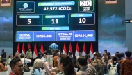 People watch carbon trading activity on a digital screen at the Indonesian stock exchange building in Jakarta on January 20, 2025. (Photo by Bay Ismoyo / AFP)