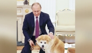 Russian President Vladimir Putin pets his Akita dog Yume at the Russian presidential office in Moscow in December 2016 / The Japan News