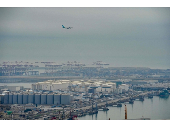 An aeroplane flies over Barcelona's port following an explosion of a tank containing a highly flammable substance in Barcelona on January 21, 2025. (Photo by Manaure Quintero / AFP)
 