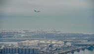 An aeroplane flies over Barcelona's port following an explosion of a tank containing a highly flammable substance in Barcelona on January 21, 2025. (Photo by Manaure Quintero / AFP)
 