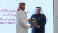 CRA President Engineer Ahmad Abdulla Al Muslemani (left) presenting the license to the Chairman and Managing Director of Qatar Post, Faleh Bin Mohammed Al Naemi during the event yesterday.