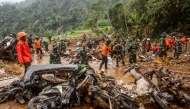 Rescue teams, including Indonesia's National Search and Rescue Agency (BASARNAS) and the Indonesian National Defence Forces (TNI), recover motorcycles from the mud following a landslide triggered by heavy rains in Kasimpar village, Central Java, on January 22, 2025. 