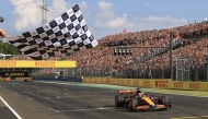 McLaren's Australian driver Oscar Piastri takes the chequered flag of the Formula One Hungarian Grand Prix at the Hungaroring race track in Mogyorod near Budapest on July 21, 2024. (Photo by MARTIN DIVISEK / POOL / AFP)

