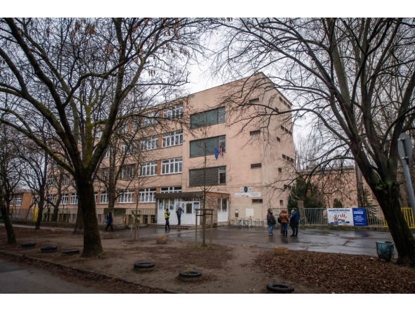 People stand in front of an empty school in Budapest on January 23, 2025 following bomb threats. (Photo by FERENC ISZA / AFP)
