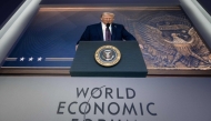 US President Donald Trump is seen on a large screen during his address by video conference at the World Economic Forum (WEF) annual meeting in Davos on January 23, 2025 (Photo by Fabrice Coffrini / AFP)
